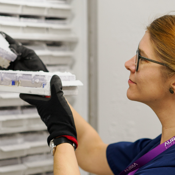 A woman takes biobank samples from a freezer.